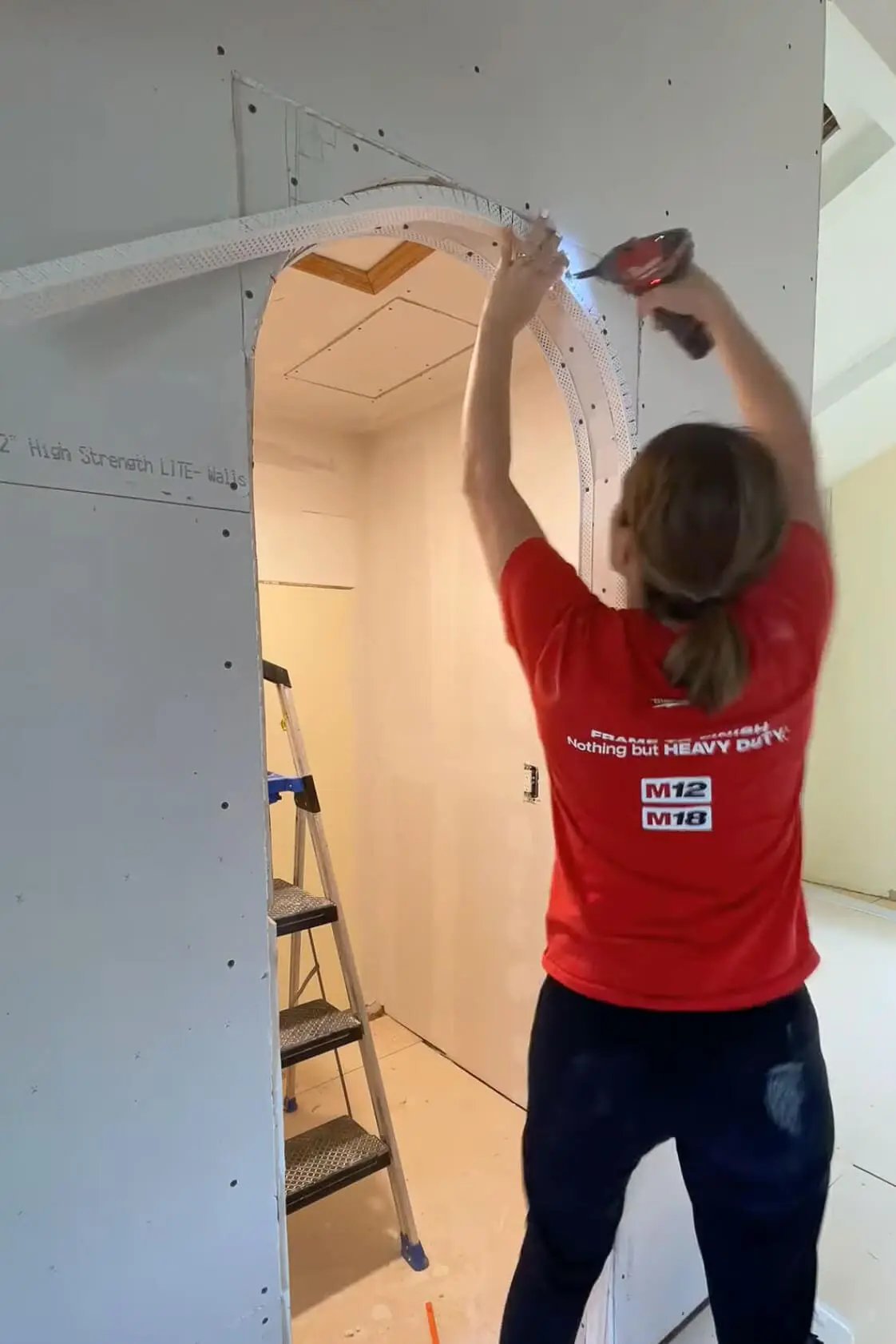 Adding corner bead while drywalling an arched doorway.